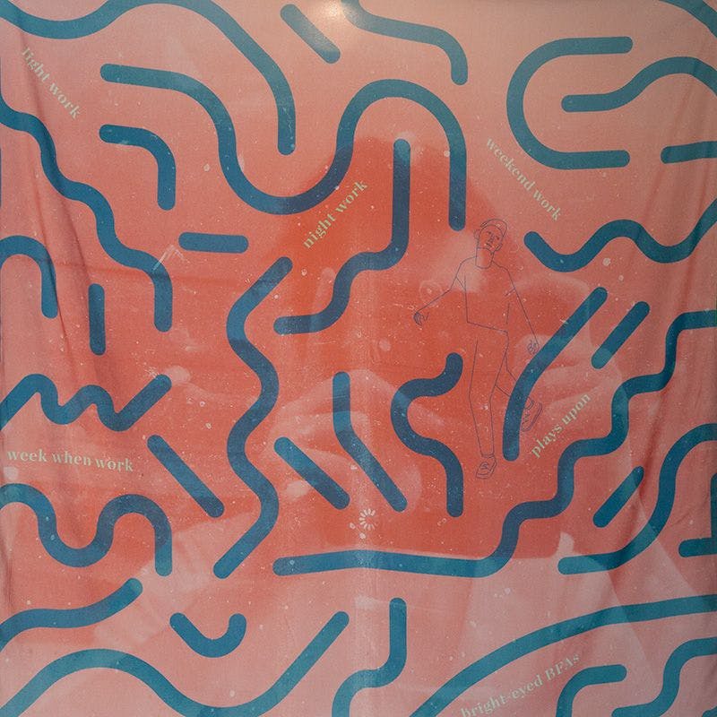 A silk print with squiggles and a reflection of person in a computer screen